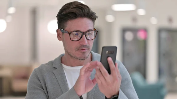 Retrato del hombre de mediana edad enfocado usando Smartphone —  Fotos de Stock