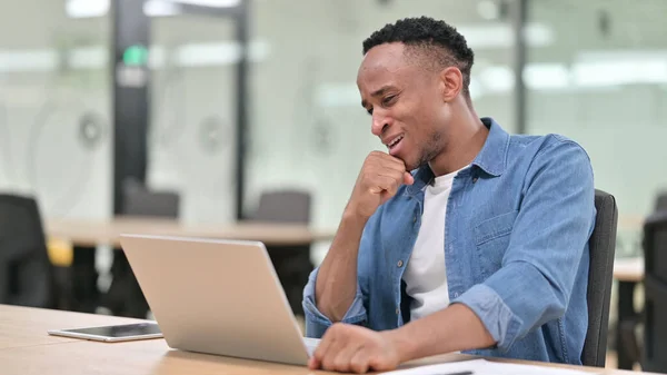 Lässiger Afrikaner enttäuscht auf Laptop im Büro — Stockfoto