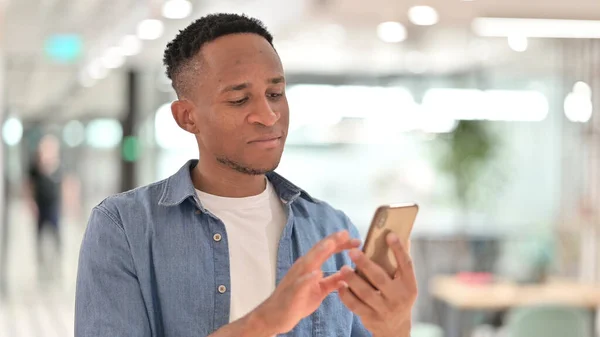 Porträt eines fokussierten, lässigen Afrikaners mit Smartphone — Stockfoto