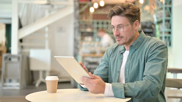 Seriös professionell medelålders man som använder surfplatta i Cafe — Stockfoto