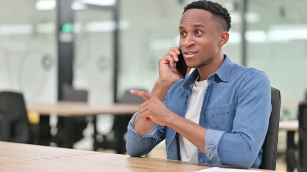 Casual African Man med bärbar dator talar på telefon — Stockfoto