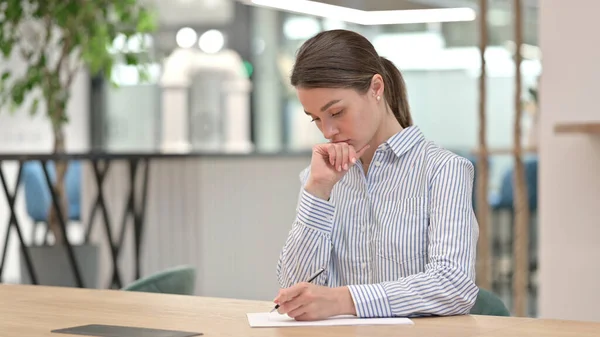 事務所で書類仕事をする真剣な若い女性 — ストック写真