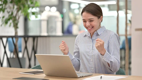 Junge Frau feiert Erfolg auf Laptop im Büro — Stockfoto