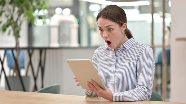 Mujer joven molesta que tiene pérdida en la tableta digital en la oficina — Foto de Stock