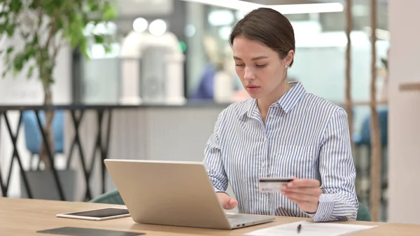 Успішна онлайн оплата ноутбука молодою жінкою в офісі — стокове фото