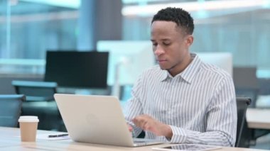 Dizüstü bilgisayarı olan genç Afrikalı iş adamı bilek ağrısı çekiyor 