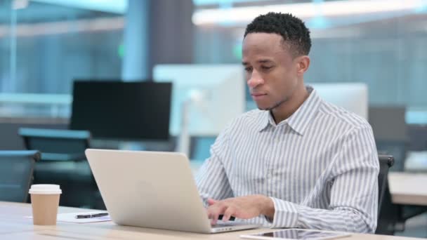 Ung afrikansk affärsman med bärbar dator har huvudvärk — Stockvideo