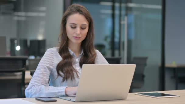 Junge Geschäftsfrau mit Laptop zeigt auf Kamera — Stockvideo