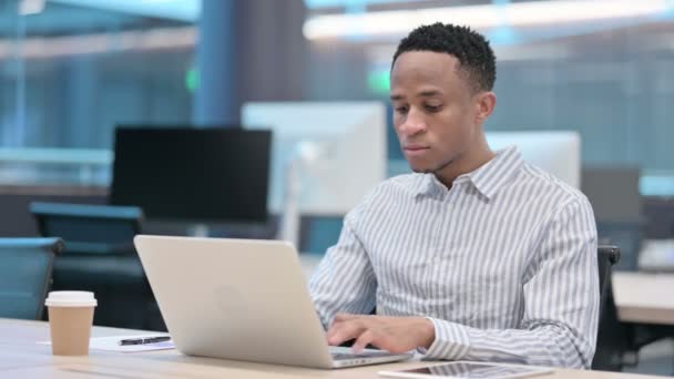 Giovane imprenditore africano che lavora sul computer portatile in ufficio — Video Stock