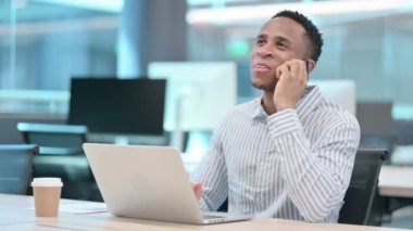 Dizüstü bilgisayarlı Afrikalı İşadamı Akıllı Telefonla Konuşuyor 