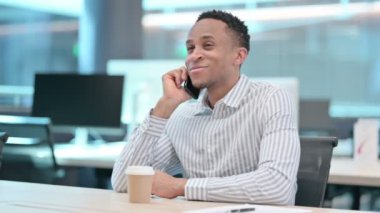 Kahveli Afrikalı İşadamı Ofiste Akıllı Telefonla Konuşuyor 