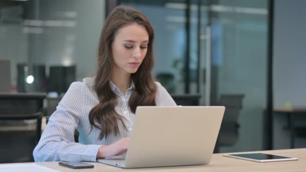 Jovem empresária olhando para a câmera enquanto trabalhava no laptop — Vídeo de Stock