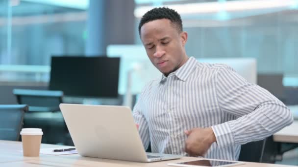 Giovane uomo d'affari africano con computer portatile con mal di schiena — Video Stock