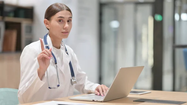 No Sign by Female Doctor with Laptop in Office