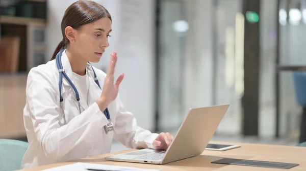 Female Doctor Thinking and Working on Laptop in Office