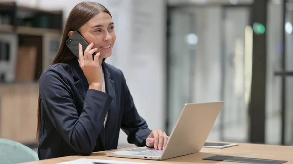 ノートパソコンを持つビジネスマンオフィスで電話で話す女性 — ストック写真