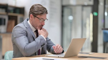 Ofisteki Laptop 'ta Düşünen ve Çalışan Dalgın İşadamı 