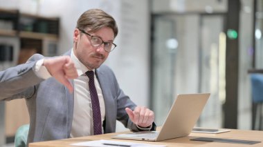 Ofiste Dizüstü bilgisayarı olan Ciddi İş Adamından Başparmak İndirme 