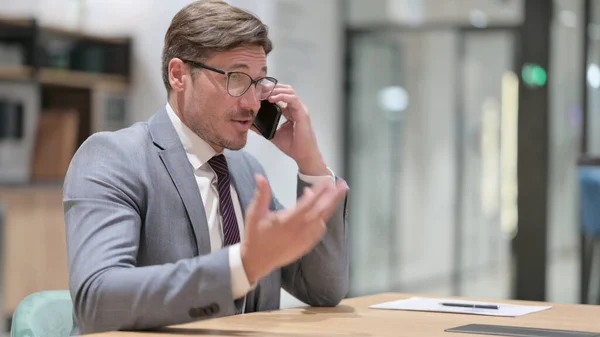 Joyeux homme d'affaires parlant au téléphone au bureau — Photo