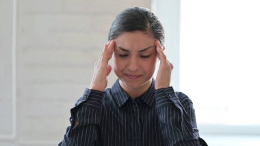 Yorgun ve genç Hintli kadın baş ağrısı çekiyor.