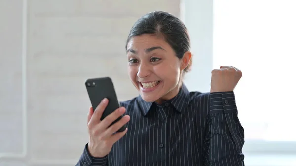 Excited Indian Woman Celebrating Success on Smartphone