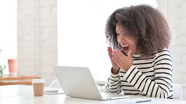 Aufgeregte Afrikanerin feiert Erfolg am Laptop — Stockfoto