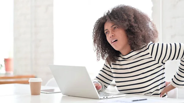 Afrikanerin mit Laptop hat Rückenschmerzen — Stockfoto