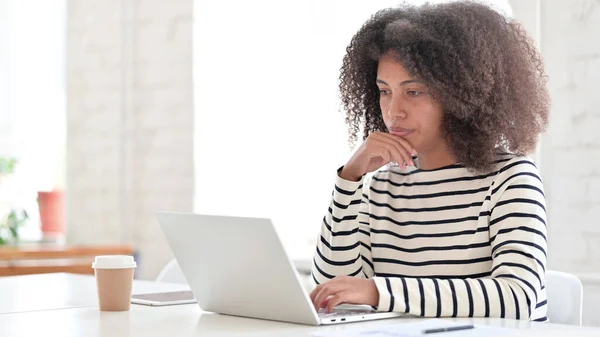 Afrikanerin mit Laptop sitzt und denkt — Stockfoto