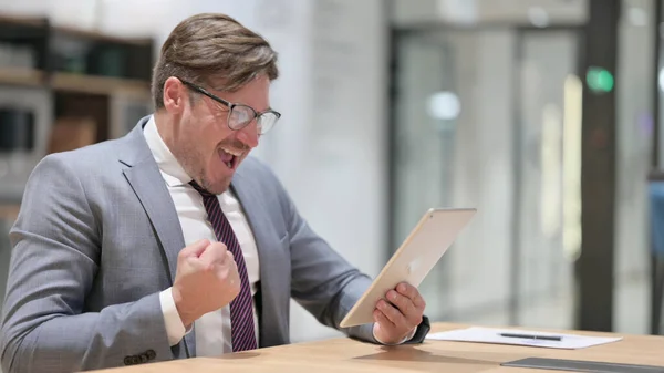 Úspěšný podnikatel slaví na tabletu v kanceláři — Stock fotografie