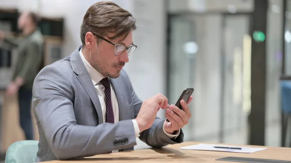 Επιχειρηματίας που χρησιμοποιεί Smartphone στο Γραφείο — Φωτογραφία Αρχείου