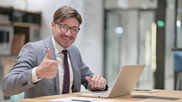 Pouce en l'air par un homme d'affaires positif travaillant au bureau — Photo