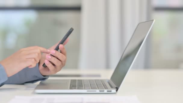 Primer plano de la mujer africana con el ordenador portátil usando Smartphone — Vídeo de stock