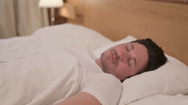 Людина середнього віку прокидається від кошмару в ліжку — стокове відео