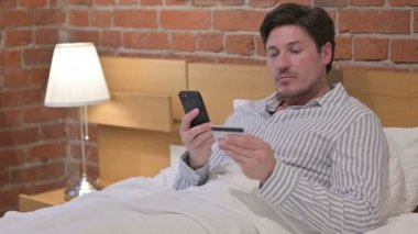 Orta Yaşlı Adam Yatakta Akıllı Telefondan Çevrimiçi Ödeme Yapıyor
