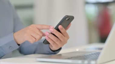 Akıllı telefon kullanan Afrikalı Kadının Kapanışı, dizüstü bilgisayarın yanında.