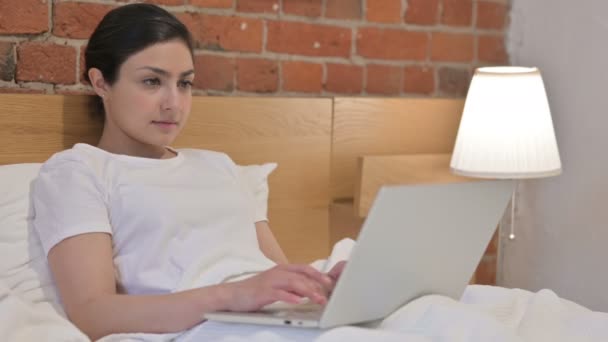 Junge Inderin arbeitet am Laptop im Bett — Stockvideo