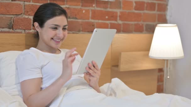 Mujer india joven usando tableta en la cama — Vídeos de Stock