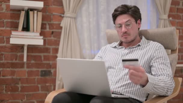 Moyen Age Homme effectuant le paiement en ligne sur ordinateur portable sur le canapé — Video