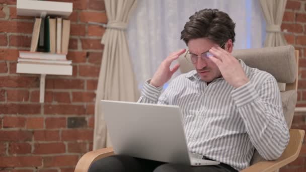 Medelålders man med bärbar dator med huvudvärk på soffan — Stockvideo