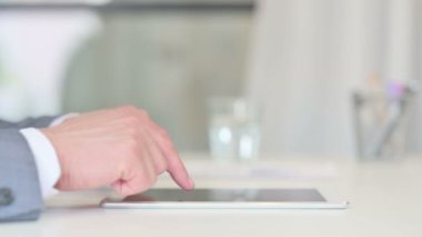 Tablet üzerinde çalışan İşadamının elleri kapalı.