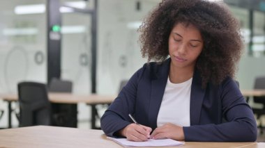 Ciddi Afrikalı Genç İş Kadını Kağıda Yazıyor 