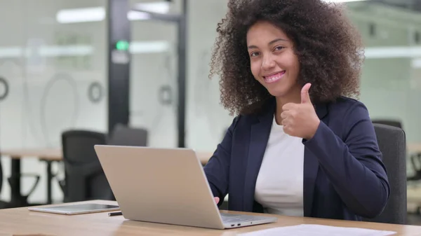 Wertschätzende junge afrikanische Geschäftsfrau mit Laptop macht Daumen hoch — Stockfoto