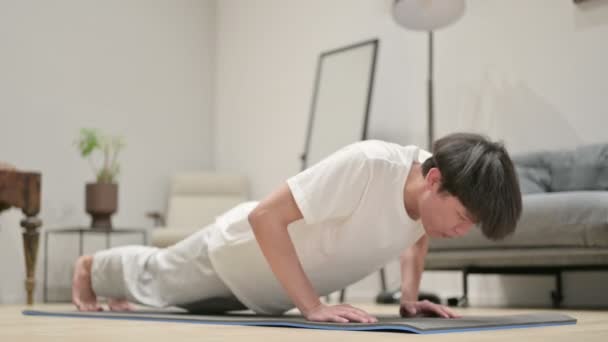 Müder asiatischer Mann macht Liegestütze auf Yogamatte zu Hause — Stockvideo