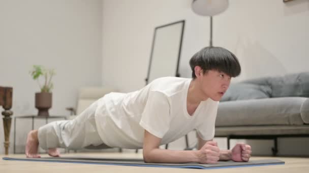 Asiatischer Mann macht Plank auf Yogamatte zu Hause — Stockvideo