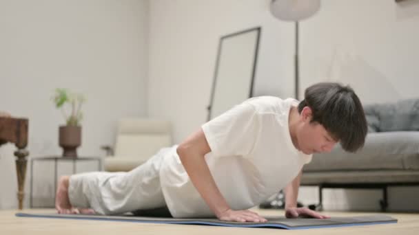 Asiatischer Mann macht Liegestütze auf Yogamatte zu Hause — Stockvideo