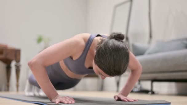 Mujer india cansada haciendo flexiones en la esterilla de yoga en casa — Vídeos de Stock