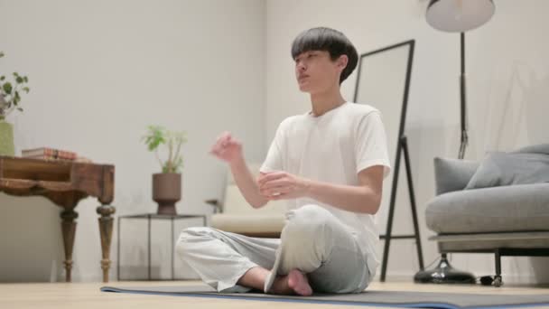 Asiatischer Mann macht Stretches auf Yogamatte zu Hause — Stockvideo