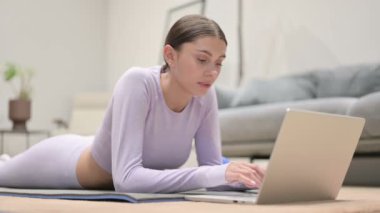 Latin Kadın Yoga Matat 'ta dizüstü bilgisayar kullanıyor.