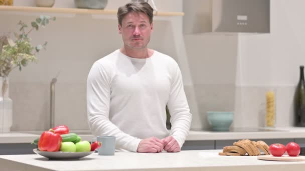 Mannen som visar tummen ner medan du står i köket — Stockvideo