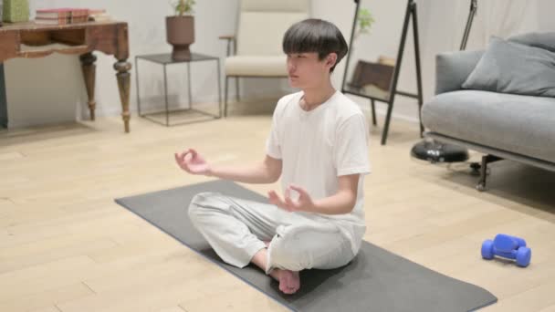 Békés ázsiai férfi otthon meditál a jóga matracon — Stock videók
